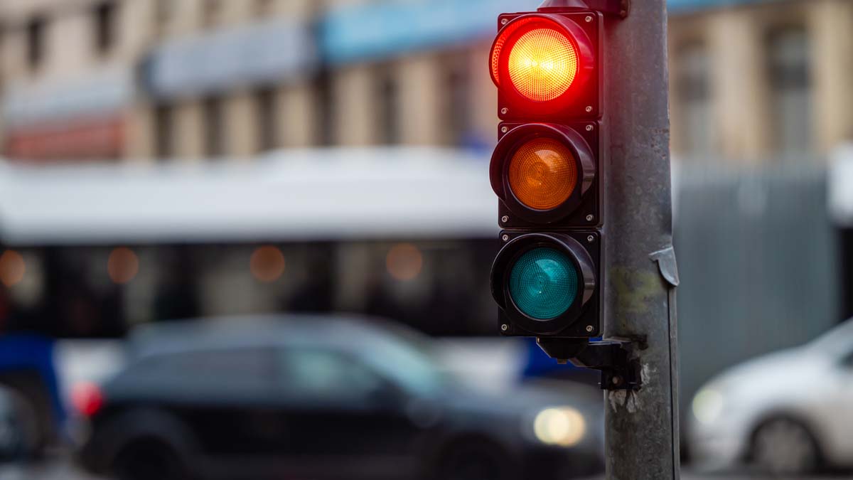 vista del tráfico de la ciudad con semáforos, en primer plano un semáforo con luz roja