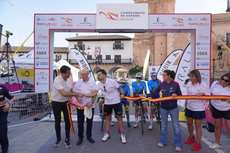 Descripción de la Imagen 1: El pelotón de ciclistas infantiles, con maillots de diversas comunidades autónomas, guarda un respetuoso minuto de silencio antes de la salida.